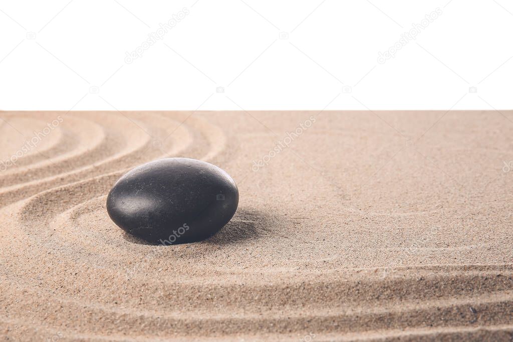 Stone on sand with lines against white background. Zen concept