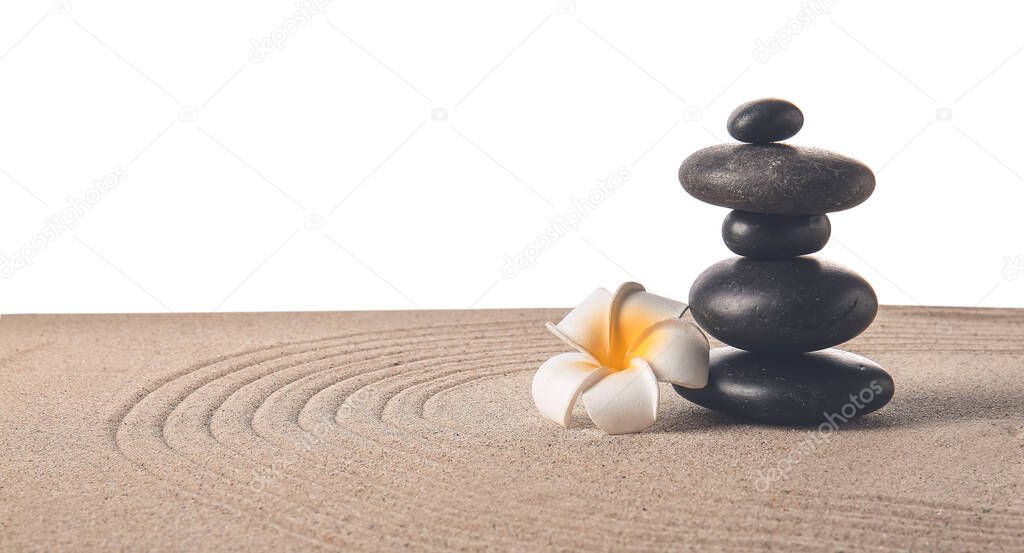 Stones and flower on sand with lines against white background. Zen concept