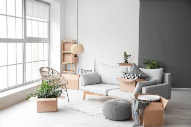 Taşındığı gün yeni dairede içinde eşyalar olan karton kutular.