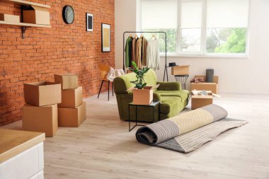 Taşındığı gün yeni dairede içinde eşyalar ve kanepe olan karton kutular.