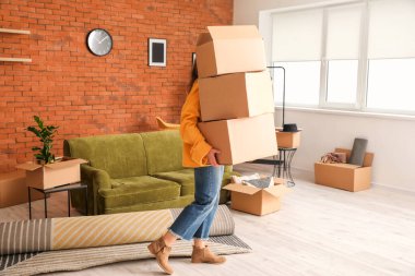 Taşındığı gün karton kutularda eşyaları olan bir kadın.