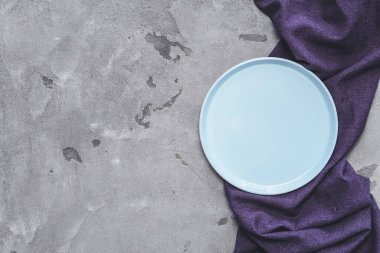 Gri arkaplanda seramik tabak ve peçete