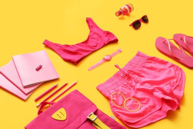 Renk arkaplanında kırtasiye malzemesi olan kadın aksesuarları ve giysiler