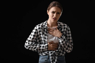 Karanlık arka planda öksüren genç bir kadın. Salgın kavramı