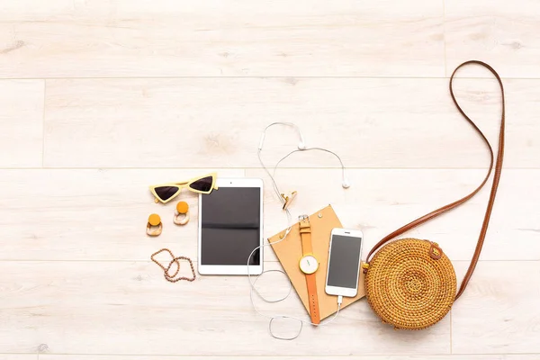 Female accessories with tablet computer and mobile phone on white wooden background