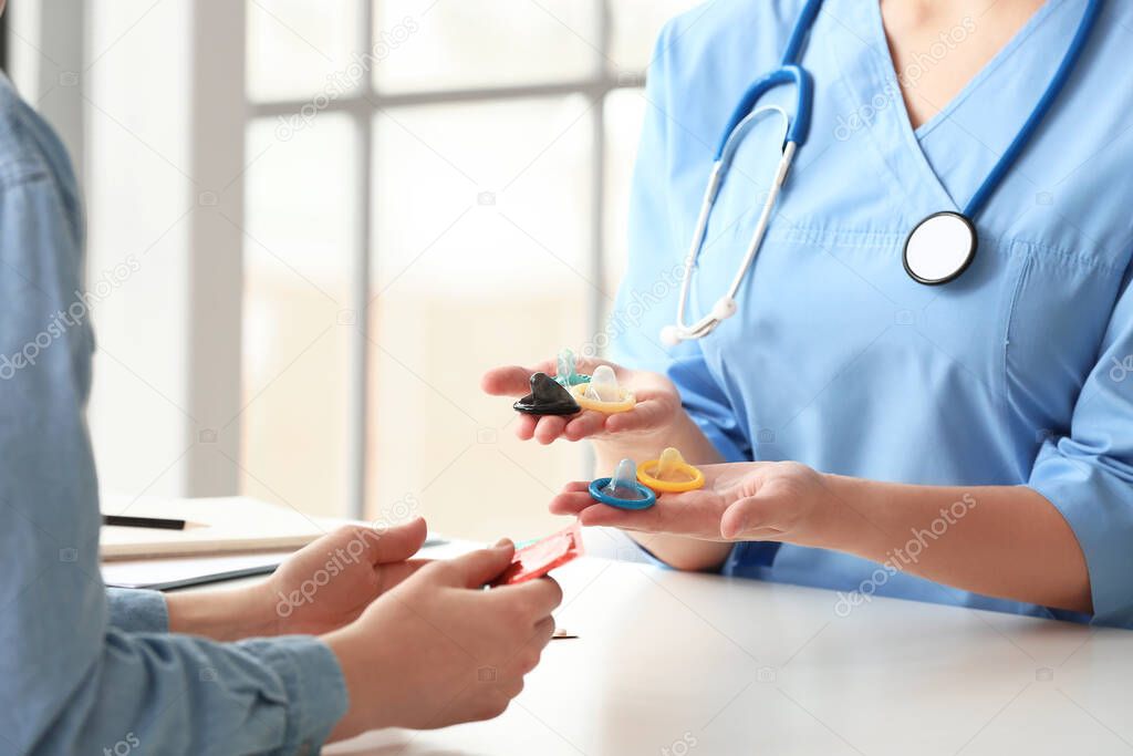 Female gynecologist and patient with condoms in clinic