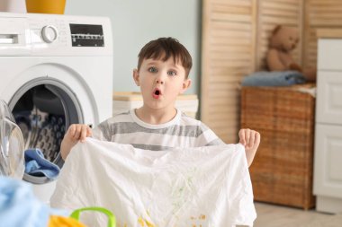 Kirli çamaşırları olan küçük bir çocuk.