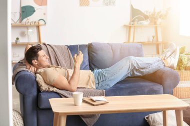 Evde cep telefonu harcayan tembel bir adam.