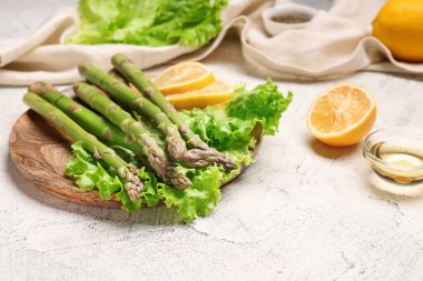 Limonlu kuşkonmaz ve arka planda yağ.