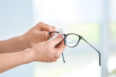 Evde gözlük dezenfekte eden kadın.