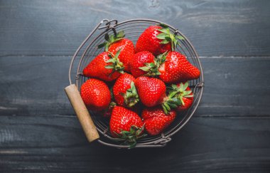 Koyu arkaplanda olgun çilekli sepet.