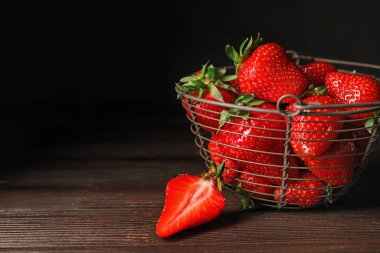 Koyu arkaplanda olgun çilekli sepet.