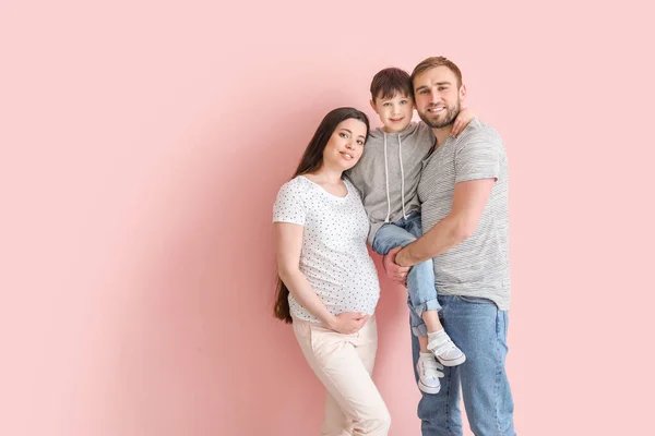 Schöne Schwangere Frau Mit Ihrer Familie Auf Farbigem Hintergrund — Stockfoto