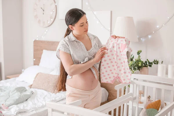 Schöne Schwangere Frau Mit Babykleidung Hause — Stockfoto