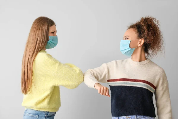 Young Women Protective Masks Greeting Each Other Grey Background Concept — Stock Photo, Image