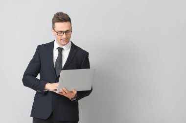 Dizüstü bilgisayarı olan yakışıklı bir iş adamı.