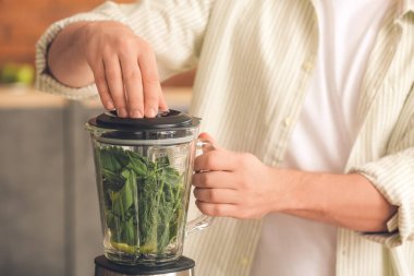 Adam evde sağlıklı smoothie yapıyor, yakın plan.