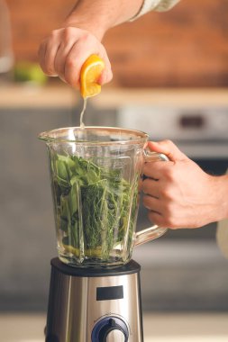 Adam evde sağlıklı smoothie yapıyor, yakın plan.