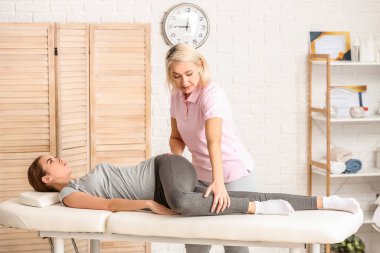 Tıp merkezinde kadın hastayla çalışan masaj terapisti.