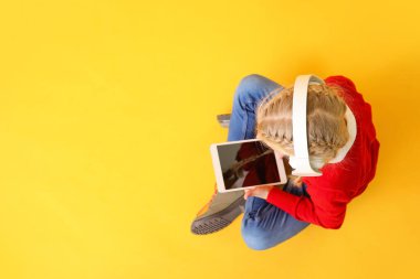 Renkli tablet bilgisayarı olan sevimli küçük bir kız. Çevrimiçi eğitim kavramı