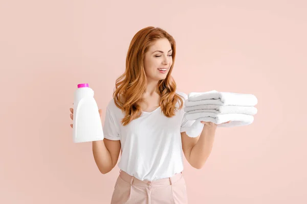 きれいなタオルと洗剤を持つ美しい女性の色の背景 — ストック写真