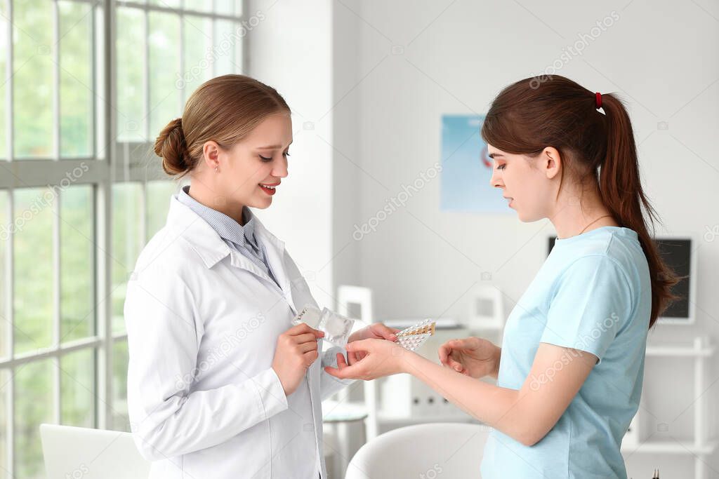 Female gynecologist and patient with different contraceptives in clinic