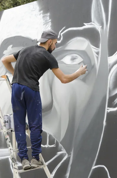 Vers Gard, Francia- octubre 16, 2016 un joven artista de graffiti durante el dibujo y la pintura de su obra de arte — Foto de Stock