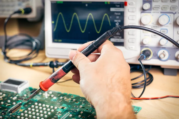 Tech tests electronic equipment in service center — Stock Photo, Image