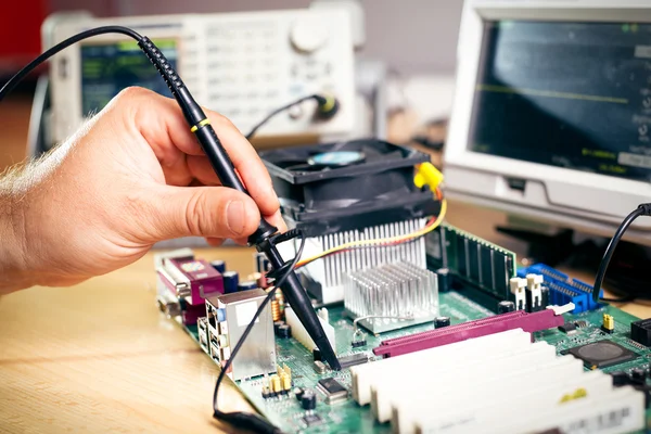Tech tests electronic equipment in service center — Stock Photo, Image