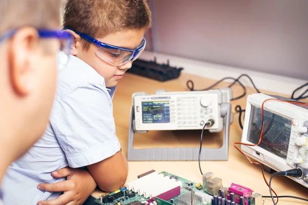 Malý chlapec a učitel ve třídě s elektronickým projektem — Stock fotografie