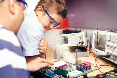 Küçük çocuk ve öğretmen ile elektronik proje sınıfı