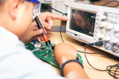 Bir elektronik proje üzerinde çalışan bir genç çocuk