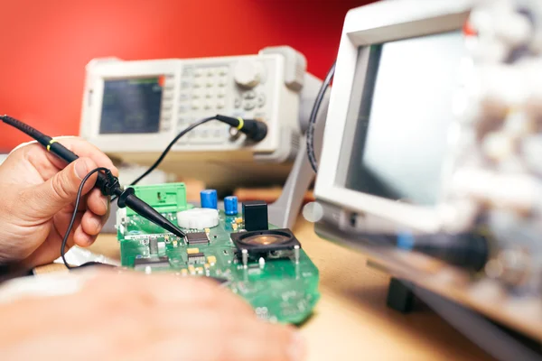 Reparador corrige equipamentos eletrônicos no centro de serviço — Fotografia de Stock