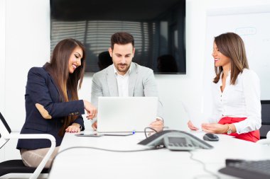 Bir grup mutlu genç iş adamı ofiste bir toplantıda.
