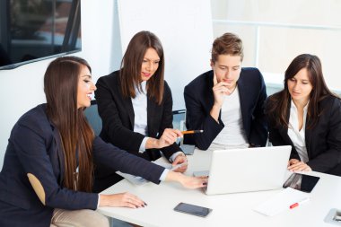 Bir grup mutlu genç iş adamı ofiste bir toplantıda.