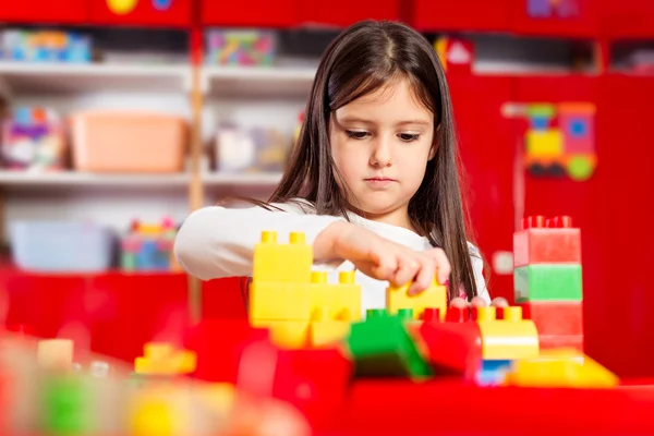 Przedszkolak bawi się kolorowymi klockami zabawek. — Zdjęcie stockowe