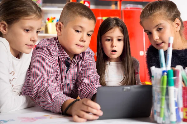 儿童在平板电脑上播放。孩子们看着电脑 — 图库照片