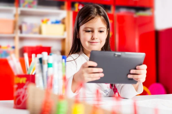 Cute little girl using tablet computer — Stock Photo, Image