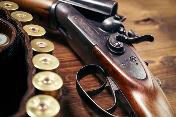 Shotgun with shells on wooden background — Stock Photo, Image