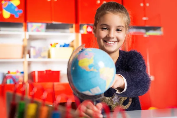 Sorrindo menina explorando globo — Fotografia de Stock