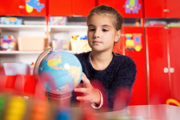 Sonriente chica explorando globo — Foto de Stock