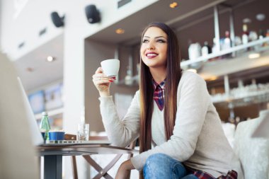 Güzel genç kız kahve içiyor.