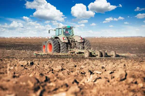 Jordbrukare i traktor förbereder mark med såbäddskultivator — Stockfoto