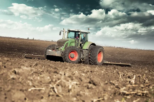 Agricultor en tractor preparando tierra con cultivador de semillero — Foto de Stock