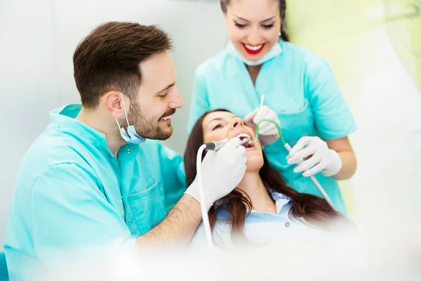 Un dentiste avec assistant travaillant sur un patient — Photo