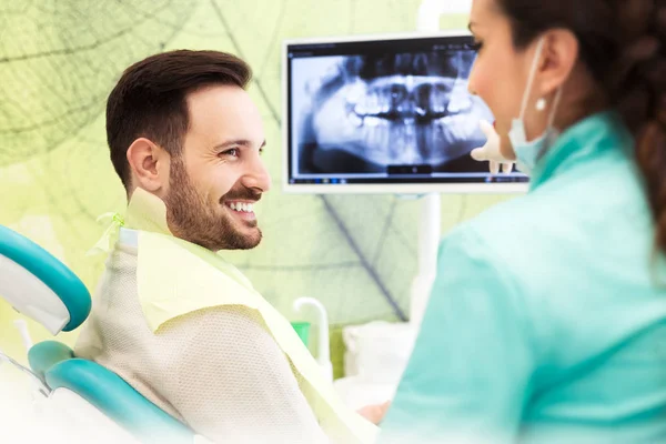 Dentist explaining x ray picture to patient — Stock Photo, Image