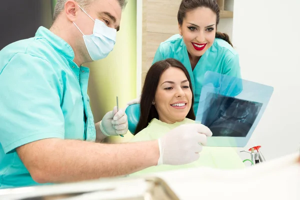 Dentista está examinando raio-X dos dentes — Fotografia de Stock