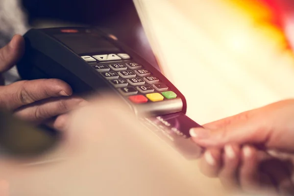 Female hand inserting credit card into a reader — Stock Photo, Image