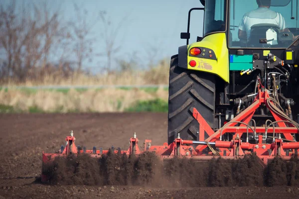 Jordbrukare i traktor förbereder mark med såbäddskultivator — Stockfoto