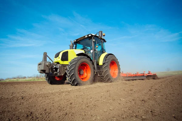 Jordbrukare i traktor förbereder mark med såbäddskultivator — Stockfoto